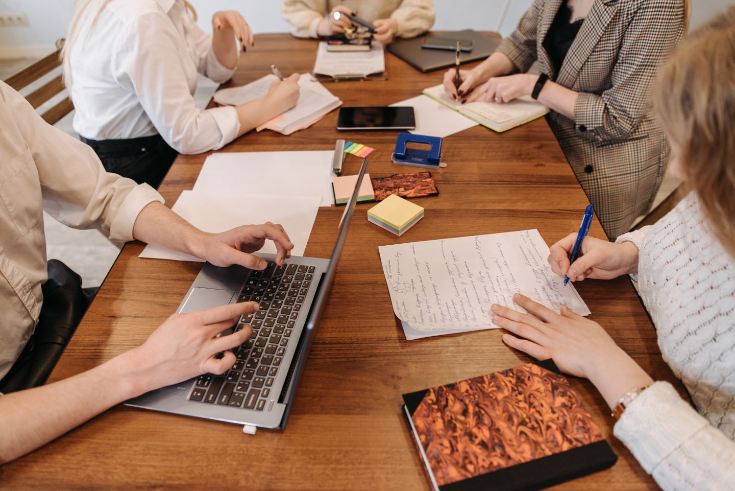 Besprechungsteilnehmer arbeiten an Projektnotizen